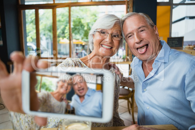 Happy senior couple taking selfie on mobile phone