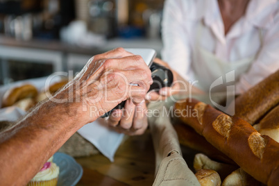 Customer making payment through NFC technology on mobile phone