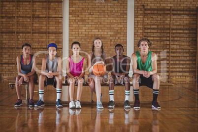 High school kids sitting on a bench in basketball court