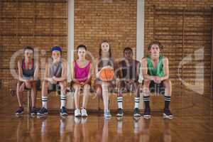 High school kids sitting on a bench in basketball court