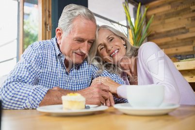 Senior couple embracing each other in cafÃ?Â©