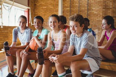 Portrait of smiling high school kids sitting on bench