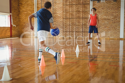 High school boys practicing football using cones for dribbling drill