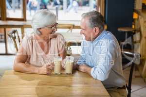 Happy senior couple interacting while having coffee
