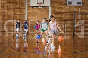 High school kids practicing football using cones for dribbling drill