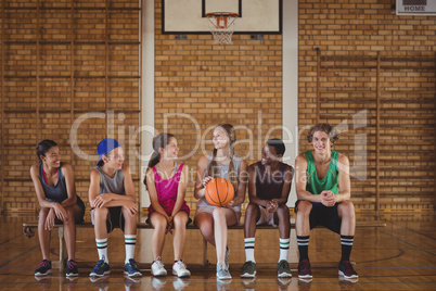 High school kids sitting on a bench in basketball court