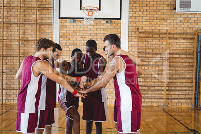 Team of basketball players stacking hands