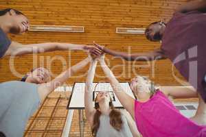 High school kids putting their hands together in basketball court