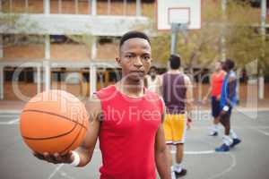 Male basketball player holding basketball in basketball court