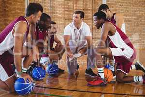 Coach explaining game plan to basketball players