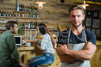 Waiter standing with arms crossed