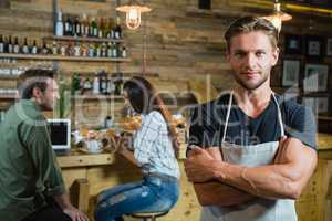 Waiter standing with arms crossed