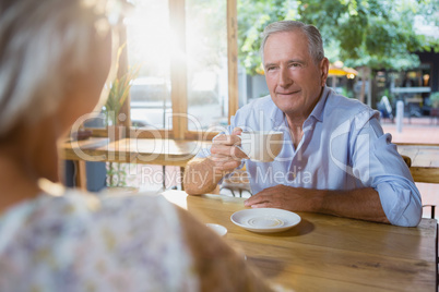 Senior couple interacting while having coffee