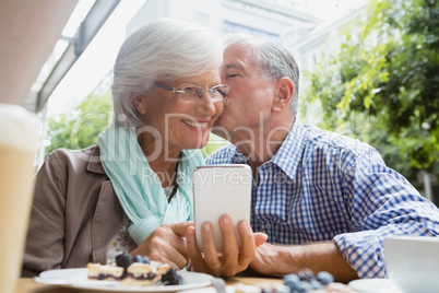 Senior man kissing woman