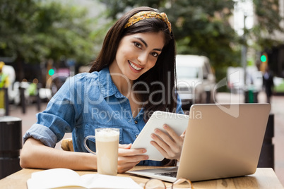 Portrait of cheerful woman holding tablet
