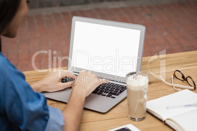 Close up of woman using laptop while sitting at table