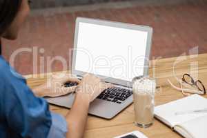 Close up of woman using laptop while sitting at table