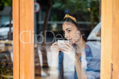 Thoughtful woman drinking coffee