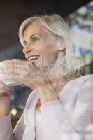 Low angle view of happy woman holding coffee cup