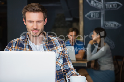 Man using laptop while having coffee