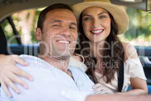 Smiling young couple sitting in car