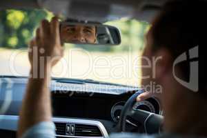 Man adjusting mirror in car