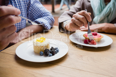 Senior couple having cupcake with blueberries and blackberries