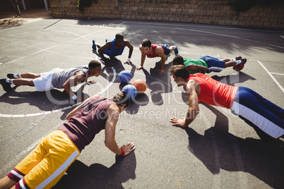 Basketball players performing push up exercise