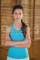 High school girl standing with arms crossed in the sports court