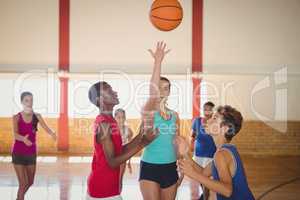 High school kids playing basketball in the court