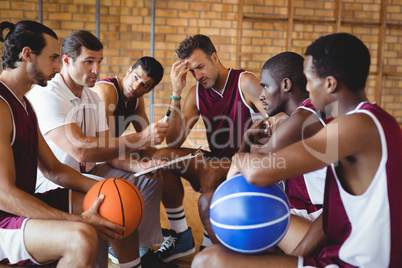 Coach explaining game plan to basketball players