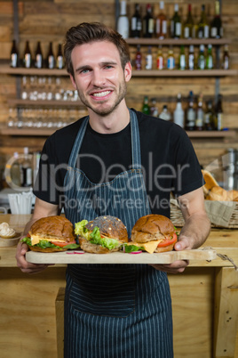 Portrait of waiter holding food at counter