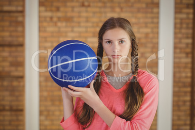 Determined girl holding a basket ball