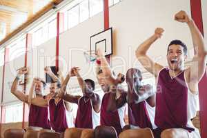 Excited basketball player sitting on bench