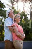 Senior couple standing against trees
