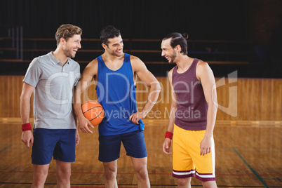 Male basketball players laughing in basketball court