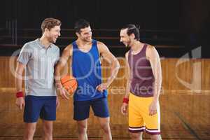 Male basketball players laughing in basketball court