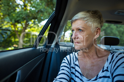 Senior woman looking through car window