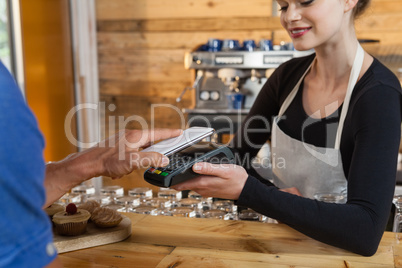Close up of man making payment on credit card reader machine