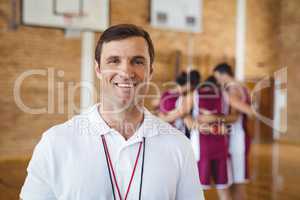 Confident coach standing in basketball court