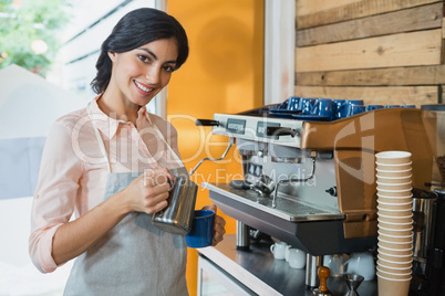 Portrait of waitress pouring coffee into cup