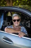 Smiling senior woman sitting in car