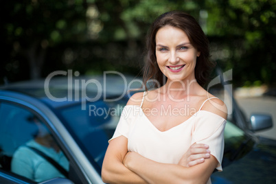 Beautiful smiling woman standing by car