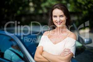 Beautiful smiling woman standing by car