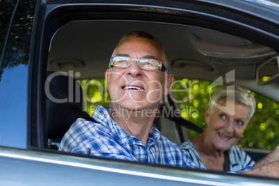 Senior couple looking outside car window