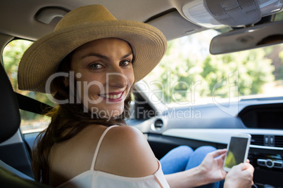 Portrait of young woman using phone in car