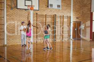 Smiling high school team defending while playing basketball