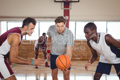 Basketball players ready for the jump ball