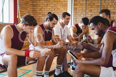 Coach and basketball players using digital tablet