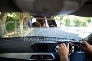 Reflection of senior man on mirror in car